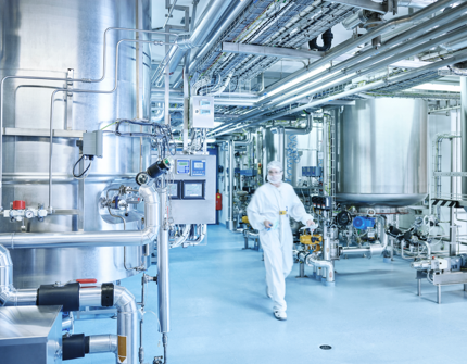 Inside an industrial plant, a laboratory technician is walking Inside an industrial plant, a laboratory technician is walking
