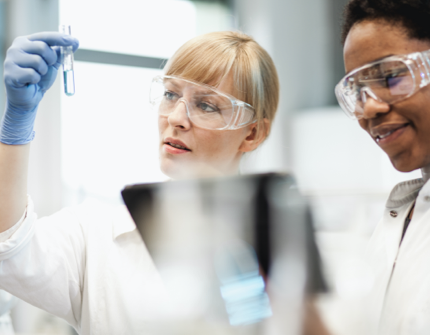 Two laboratory technicians, one of them is looking to a sample