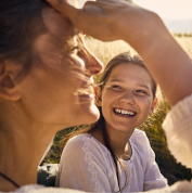 A girl smiling at another woman in a field